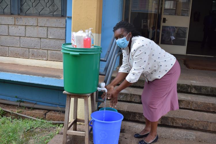 Senior Administrator washing her hands as she wait for the stakeholders to arrive