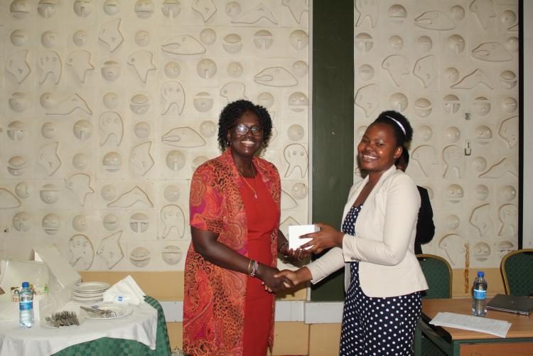 Final year student presenting a gift to CAS, East African Community